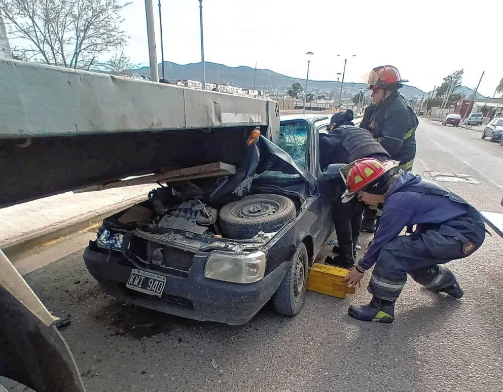 Un auto chocó violentamente y terminó debajo del acoplado de un camión: Su conductor resultó seriamente herido