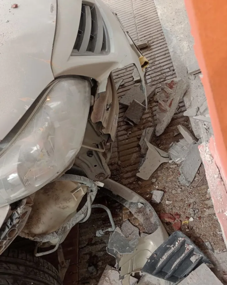 Auto estacionado fue impactado por otro vehículo y provocó daños en una agencia de quiniela