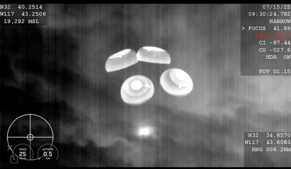Esta imagen tomada de un video proporcionado por SpaceX muestra la cápsula con cuatro astronautas cayendo con varios paracaídas sobre el océano Pacífico.