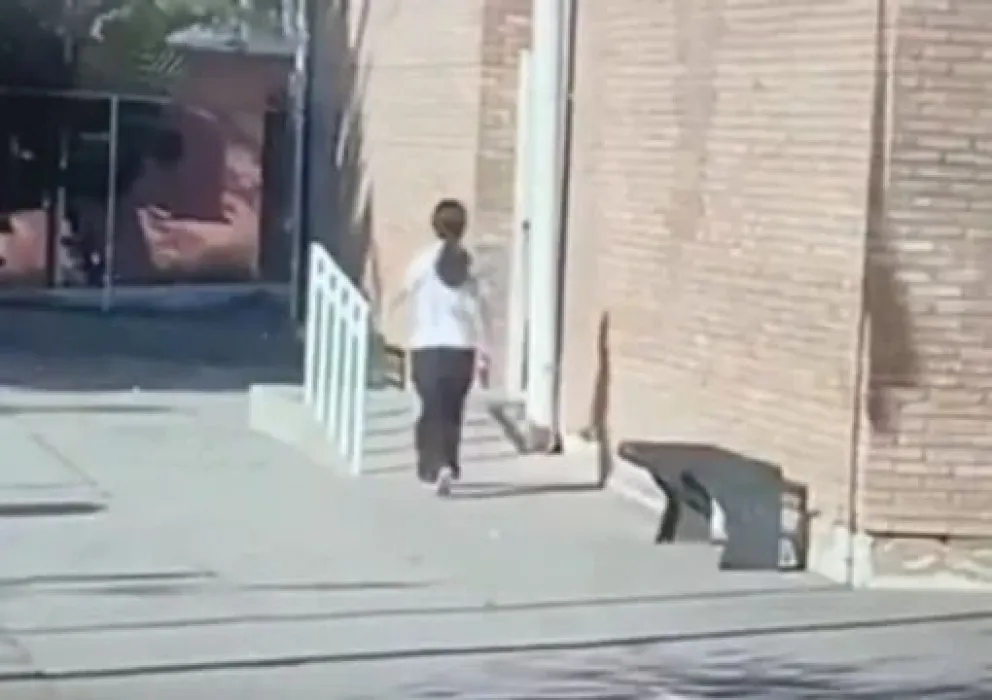 En la imagen se observa a la adolescente con una pistola en sus manos y caminando para ingresar a la escuela.