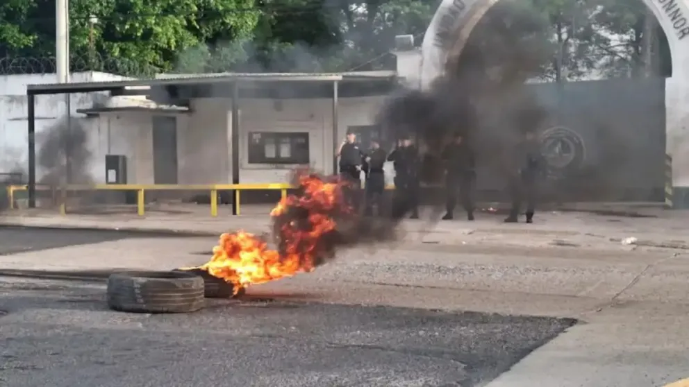 Una joven sostiene un bidón con combustible en la protesta en la puerta del penal.