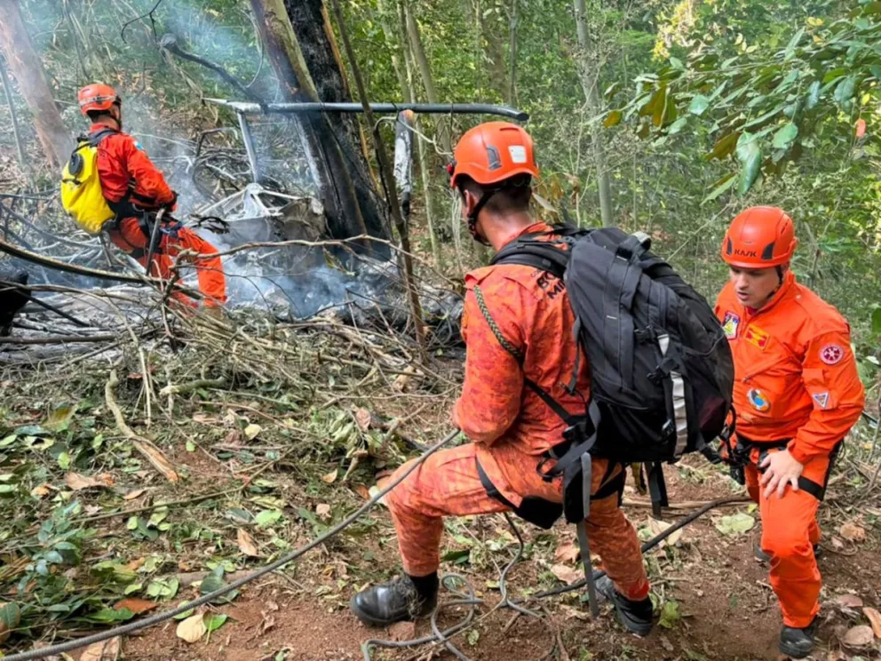 Bomberos trabajan en el lugar donde ocurrió el accidente de un helicóptero este sábado, en el bosque de Tijuca, en Río de Janeiro (Brasil).